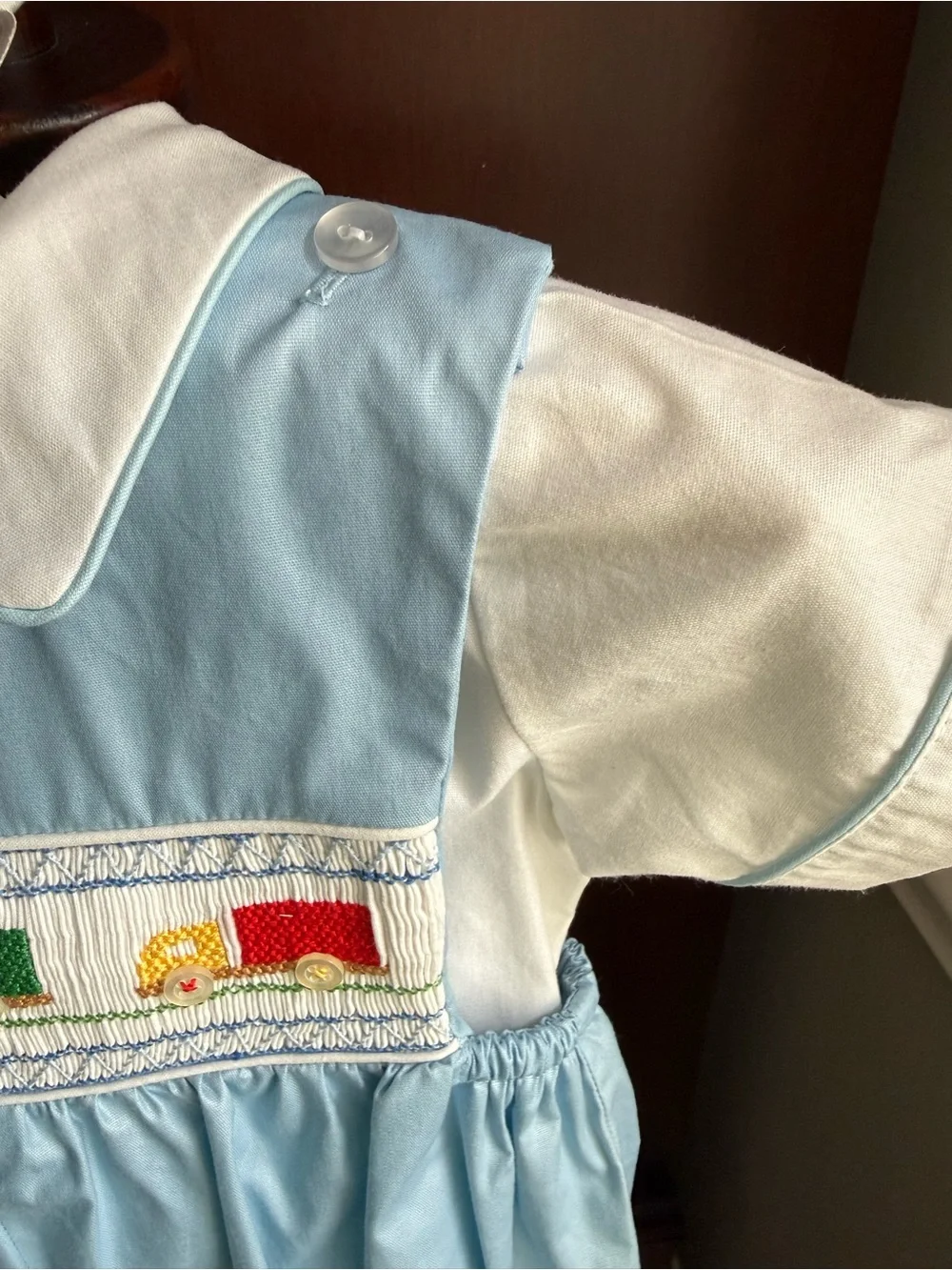 House of Hatten Smocked Blue & White Baby Romper with Colorful Truck Motif